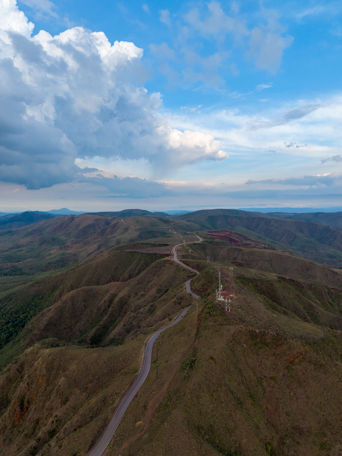 Aerial panorama of green mountain ridges and rolling hills near Belo Horizonte, Minas Gerais, beneath dramatic clouds.