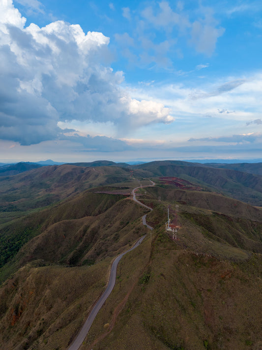 Aerial panorama of green mountain ridges and rolling hills near Belo Horizonte, Minas Gerais, beneath dramatic clouds.