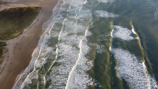 Aerial view of ocean waves meeting the sandy Texas Gulf Coast shoreline.