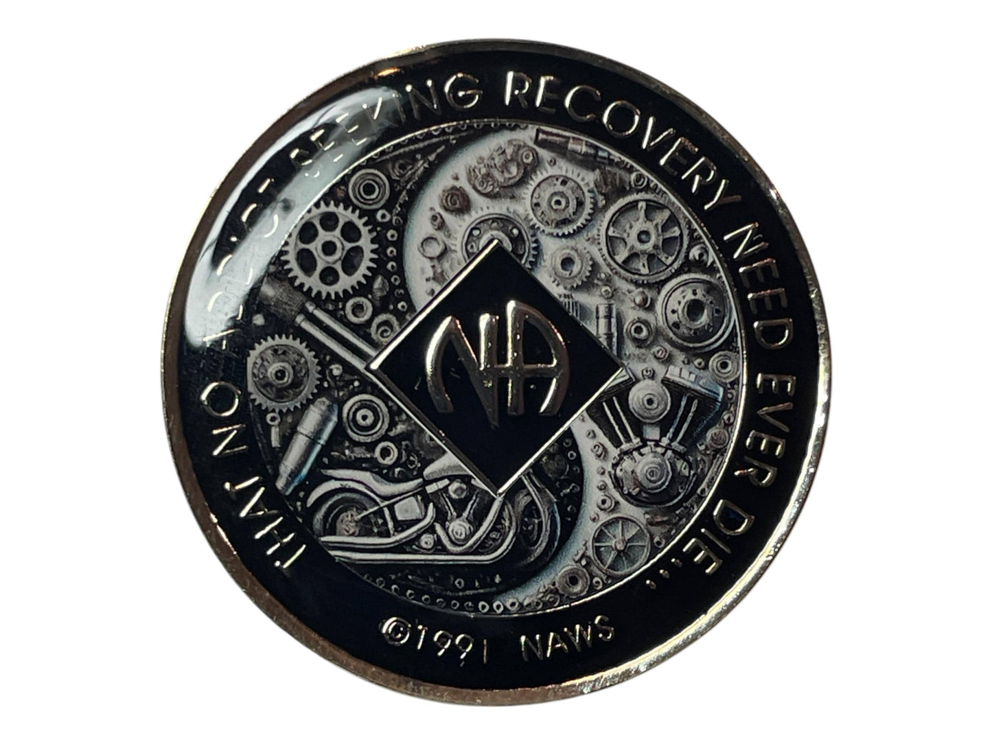 Narcotics Anonymous medallion with black and silver gear and motorcycle engine design, featuring the NA symbol and the quote ‘That No Addict Seeking Recovery Need Ever Die,’ symbolizing strength, unity, and progress in recovery.