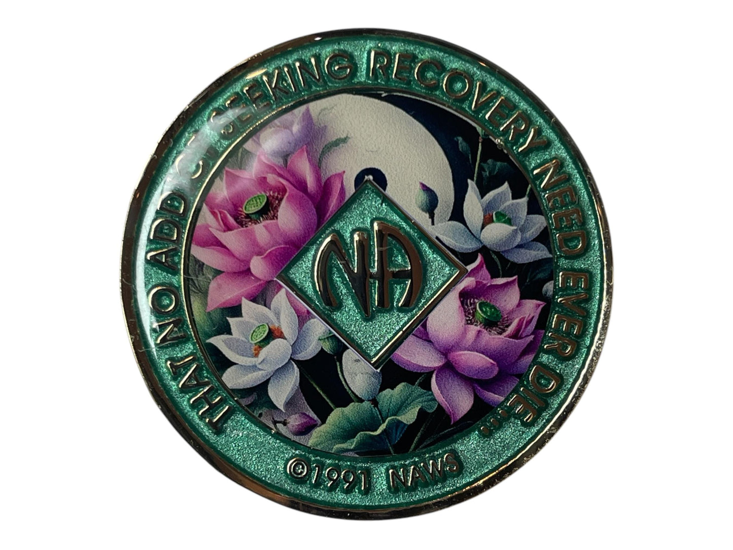 Narcotics Anonymous recovery medallion with shimmering green border, NA diamond logo, and lotus flower artwork under a moon, featuring the phrase ‘That No Addict Seeking Recovery Need Ever Die.’