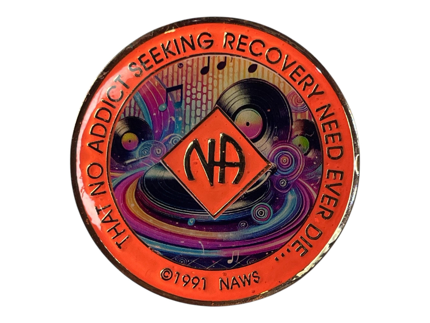 Narcotics Anonymous recovery medallion with vibrant orange border, NA diamond logo, and colorful music-themed artwork featuring vinyl records and musical notes, with the phrase ‘That No Addict Seeking Recovery Need Ever Die.’