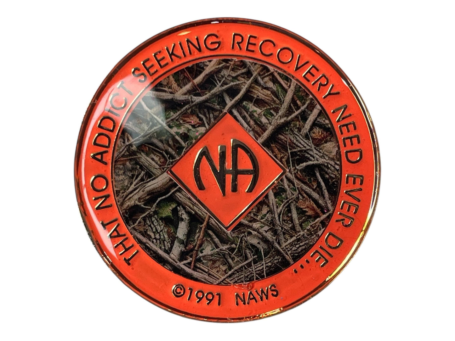 Narcotics Anonymous recovery medallion featuring a camouflage forest floor design with twigs and leaves, symbolizing resilience, grounding, and personal growth through recovery. The medallion has a bright orange metallic border engraved with “That No Addict Seeking Recovery Need Ever Die,” and a central NA logo, representing hope, unity, and strength in sobriety.