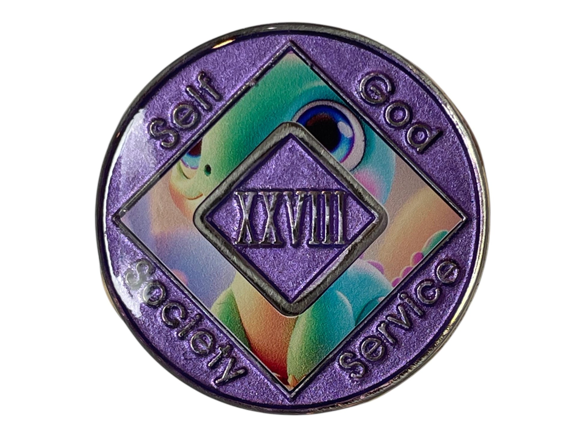 Narcotics Anonymous 28-year sobriety medallion with shimmering purple border, cute baby dinosaur artwork, and the words Self, God, Society, Service surrounding the Roman numeral XXVIII.