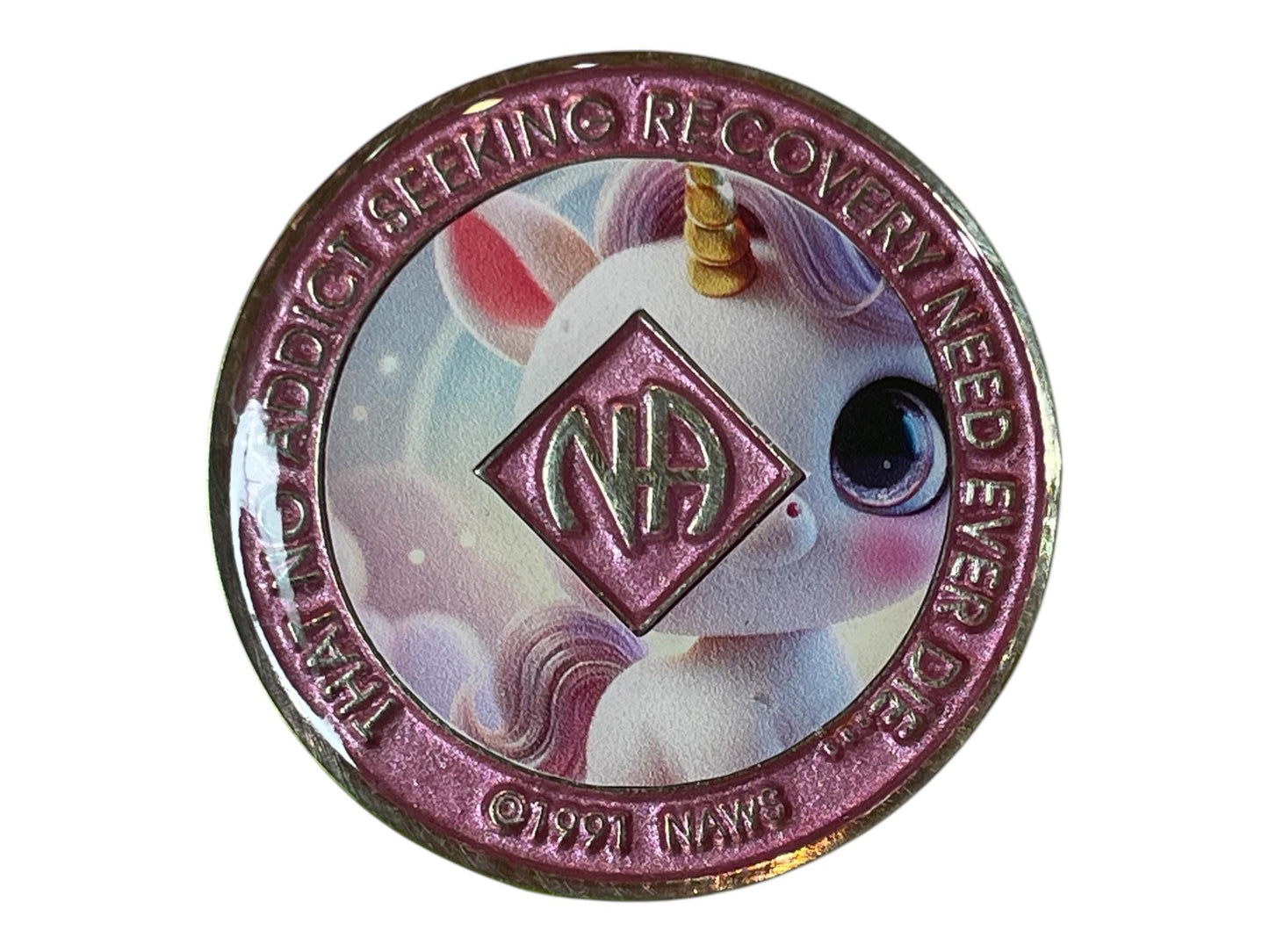 Narcotics Anonymous recovery medallion featuring an adorable pastel unicorn design, symbolizing hope, innocence, and the magic of transformation in recovery. The medallion has a shimmering pink border with the NA logo at the center and the words “That No Addict Seeking Recovery Need Ever Die,” representing healing, positivity, and renewed life on the journey of sobriety.