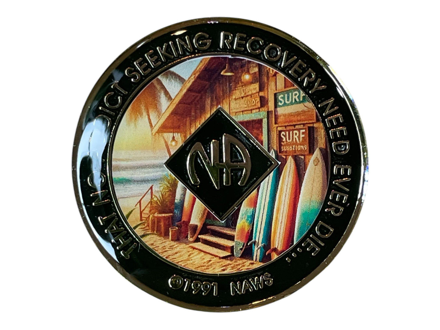 Narcotics Anonymous beach-themed recovery medallion featuring a surf shack with colorful surfboards, ocean waves, and palm trees, symbolizing serenity and freedom in recovery, with the NA logo and quote “That No Addict Seeking Recovery Need Ever Die.”