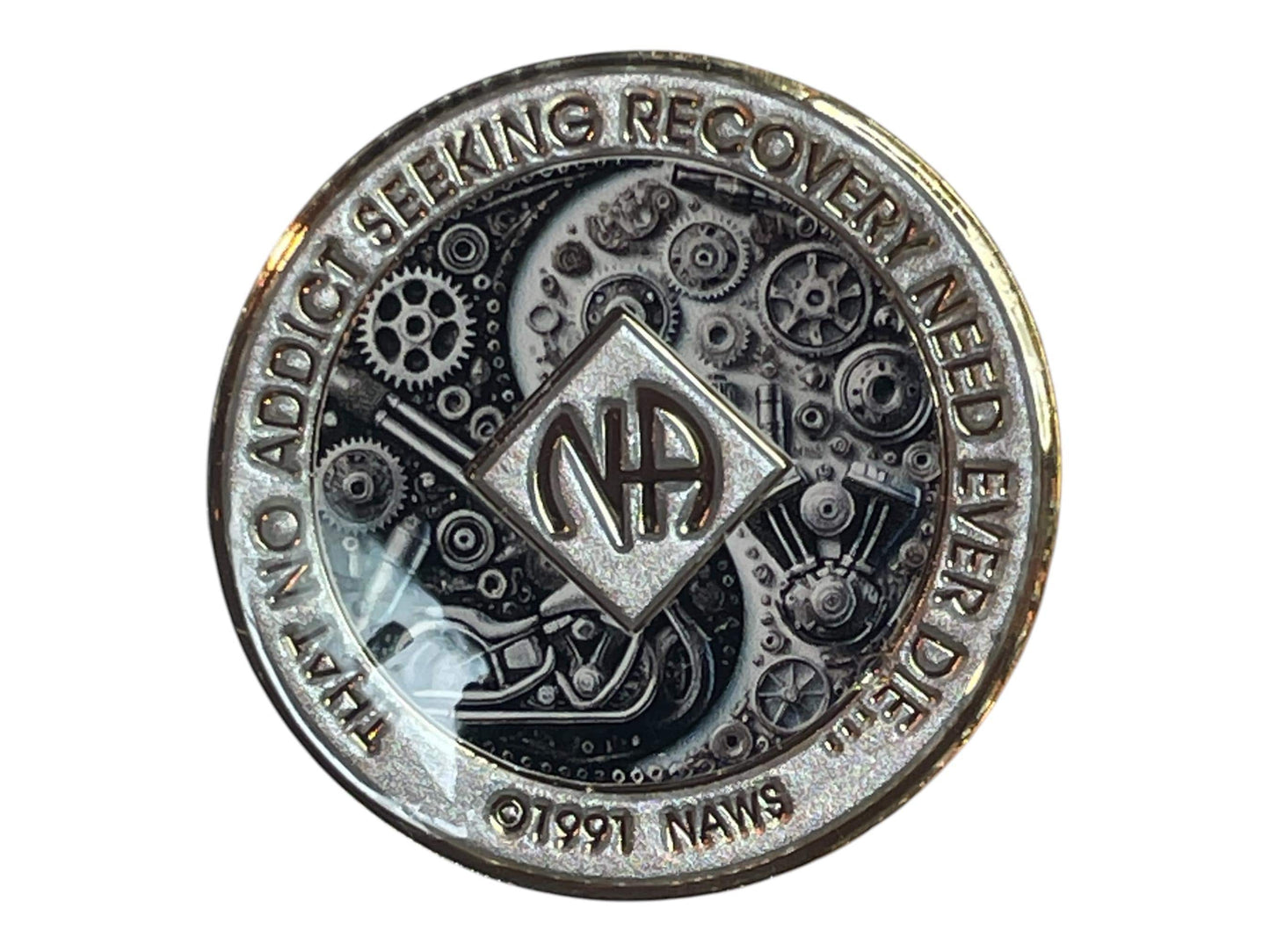 Narcotics Anonymous silver recovery medallion featuring intricate black and chrome mechanical gears and motorcycle artwork with NA logo and quote ‘That no addict seeking recovery need ever die,’ symbolizing strength, perseverance, and unity in recovery.