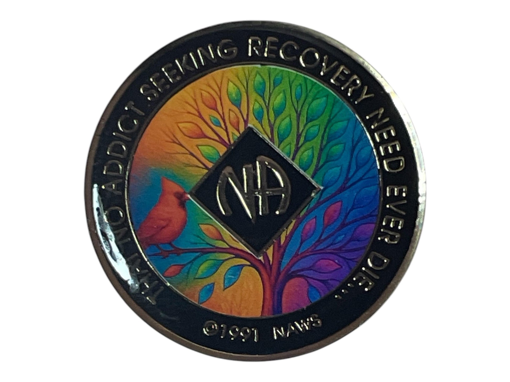 Narcotics Anonymous recovery medallion featuring a vibrant rainbow-colored tree of life and a red cardinal bird. The NA logo is centered, surrounded by the inscription “That No Addict Seeking Recovery Need Ever Die,” symbolizing hope, spiritual growth, and renewal in recovery.
