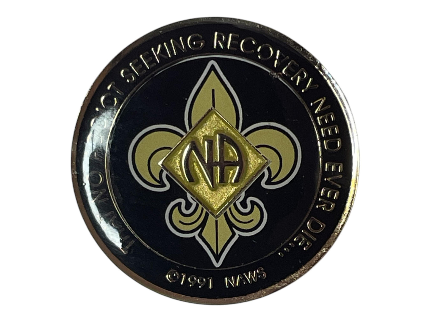 Narcotics Anonymous gold and black medallion featuring the NA logo centered on a fleur-de-lis design with the phrase “That No Addict Seeking Recovery Need Ever Die” around the border, symbolizing strength, unity, and recovery.
