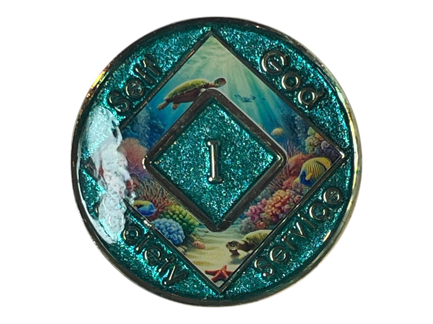 A teal-colored Narcotics Anonymous medallion with a glittery finish. The center features a teal diamond shape with the number '1' in the middle. The background depicts an underwater scene with coral, fish, and sea turtles. The words 'SELF', 'GOD', 'SERVICE', and 'UNITY' are inscribed around the edges.