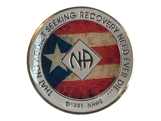 Narcotics Anonymous recovery medallion featuring a rustic Puerto Rican flag background, symbolizing pride, unity, and strength in recovery. The design includes the NA logo at the center with a silver border engraved with the phrase “That No Addict Seeking Recovery Need Ever Die,” representing hope, perseverance, and community for members celebrating their clean time.