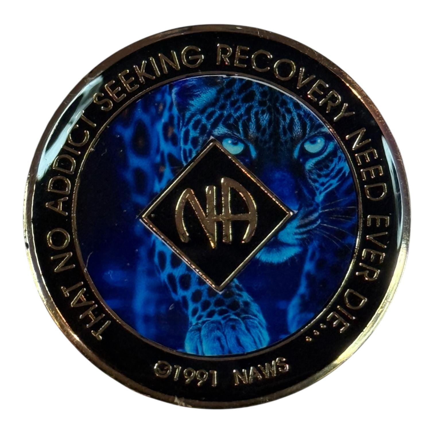 Narcotics Anonymous blue recovery medallion featuring a powerful leopard design with the NA logo in the center, symbolizing courage, resilience, and spiritual strength in addiction recovery.