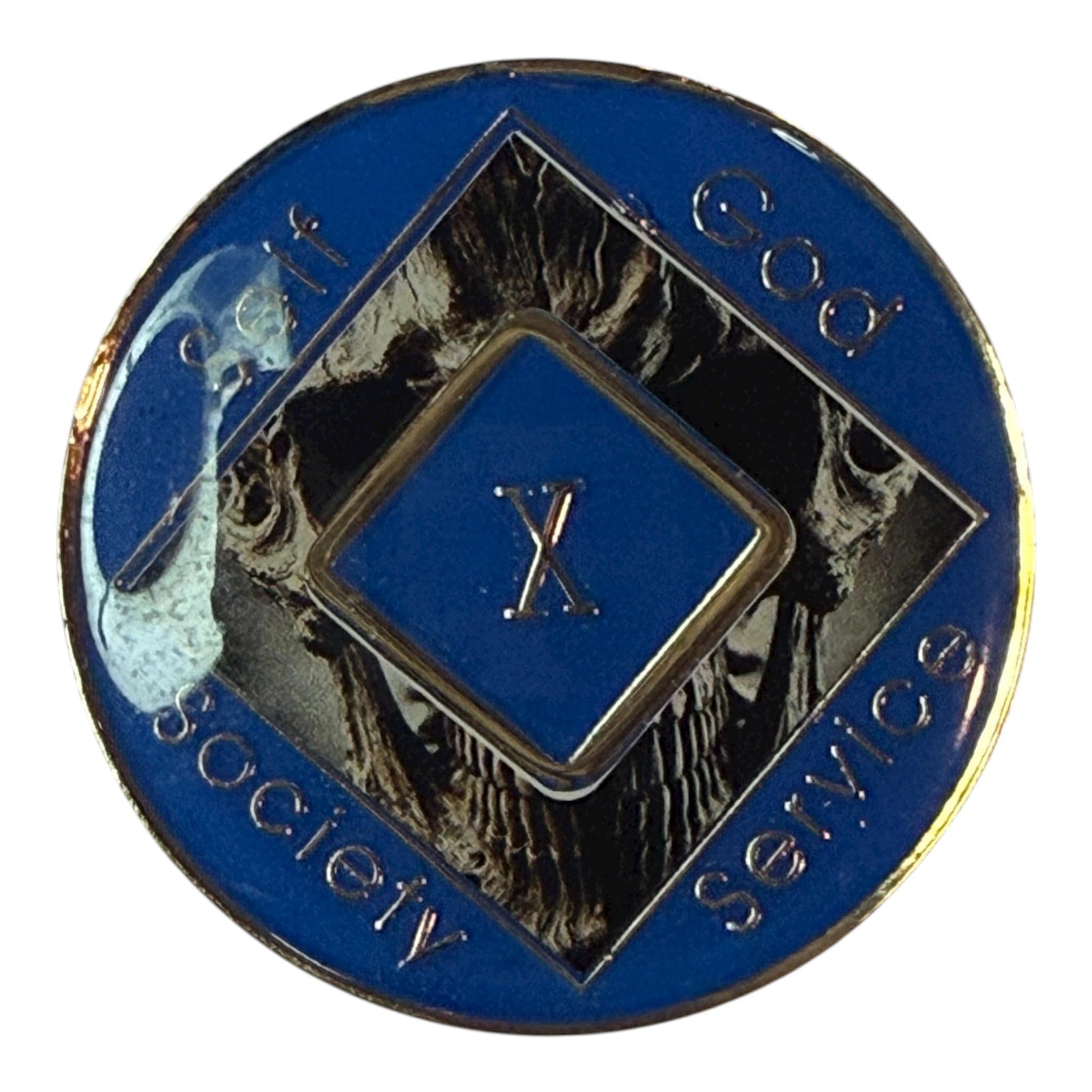 Narcotics Anonymous 10-year recovery medallion featuring a dark skull design with metallic detailing and a blue enamel border. The center diamond displays “X,” surrounded by the words “Self, God, Society, Service,” symbolizing a decade of strength, transformation, and perseverance in recovery.
