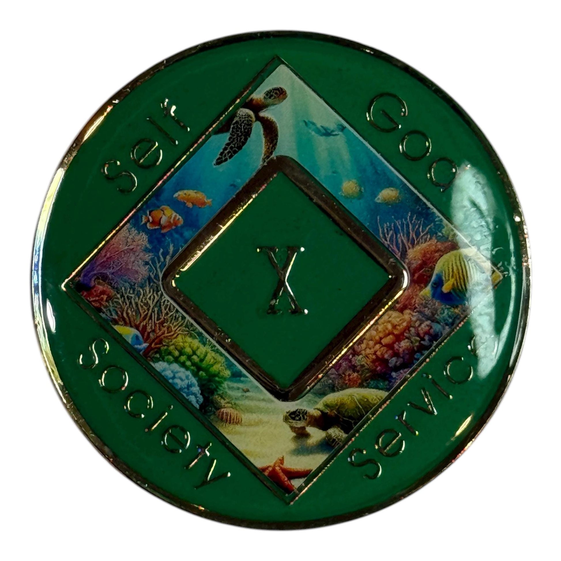 Narcotics Anonymous 10-year recovery medallion featuring a sea turtle swimming over a colorful coral reef, symbolizing endurance and peace. The coin has a green border with the words “Self, God, Society, Service” and Roman numeral X in the center, representing 10 years clean and a decade of spiritual growth in recovery.